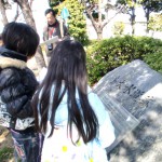 大野川緑陰道路にある中島大水道の石碑にて説明を聞く小学生。